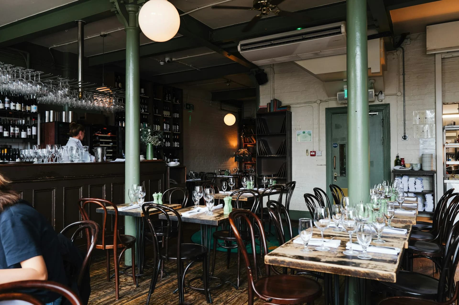 Tables de bistrot et comptoir dans une salle chaleureuse